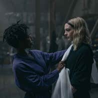 A woman is putting a shawl on another woman.