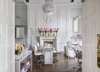 Nail salon with desk and chairs with flowers in vases