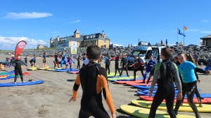 Group in the beach standing on surf boards