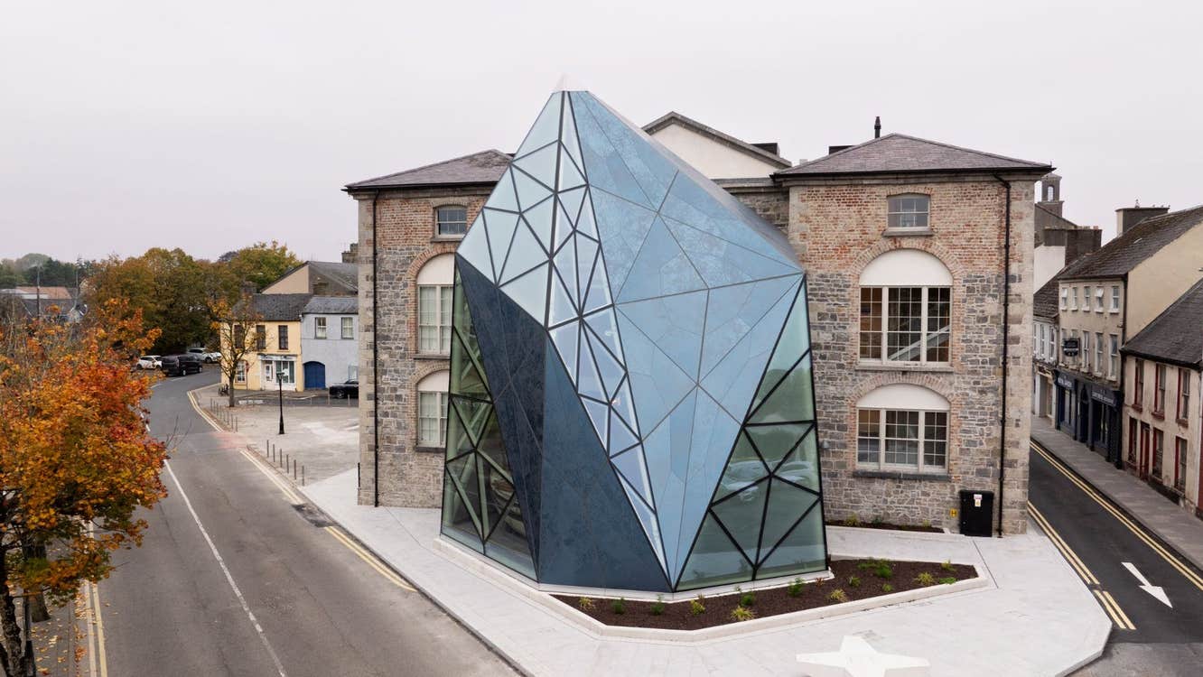 Exterior view of a historic building with a large glass structure attached