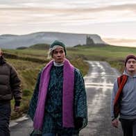 4 adults walking along a country lane on a dull day.