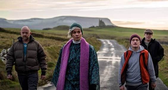 4 adults walking along a country lane on a dull day.