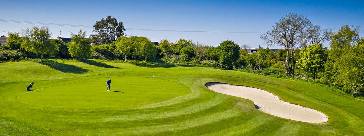 Balbriggan Golf Club player on a green with trees and a sandtrap