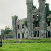 Image of three children on the lawn in front of the ruins of Castle Saunderson
