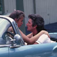 A man and a woman in a car, staring lovingly into each other's eyes.