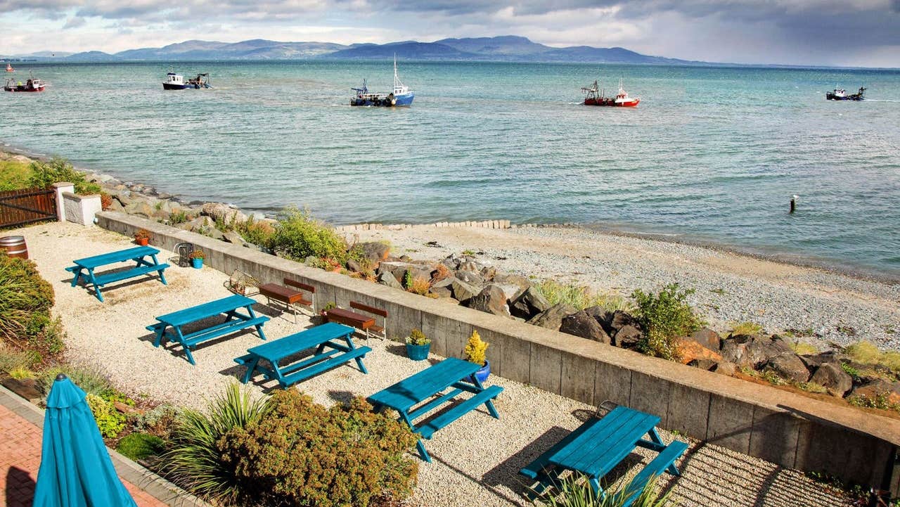 A view of the sea and fishing boats from restaurant with picnic benches