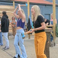 Group participating in outdoor axe throwing session with instructors