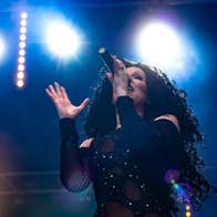 Viewed from below looking upwards at woman singing with spotlights behind.
