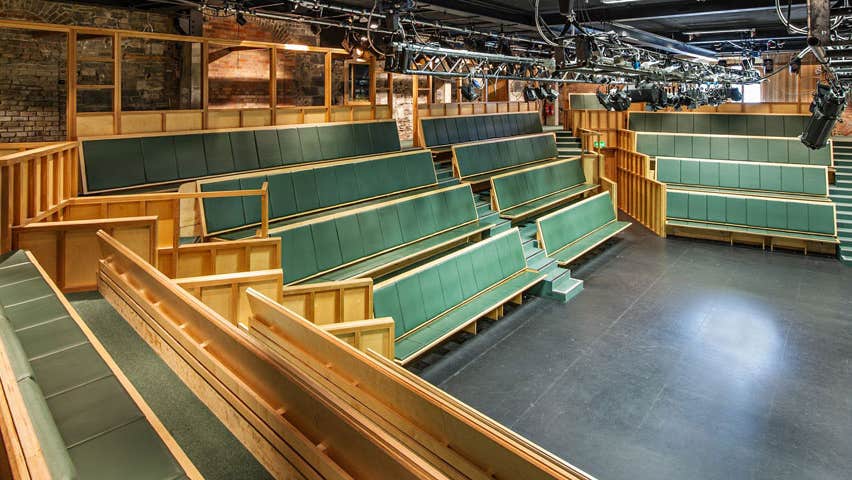 Tiered seats facing a stage in a theatre
