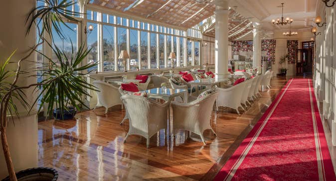 A row of tables and chairs along  a line of windows at the Aroma Café