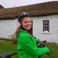 Lady stands with her electric bicycle at Glencolmcille Folk Village Experience with Ireland By Bike