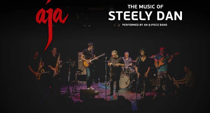 A group of 8 musicians on a small stage
