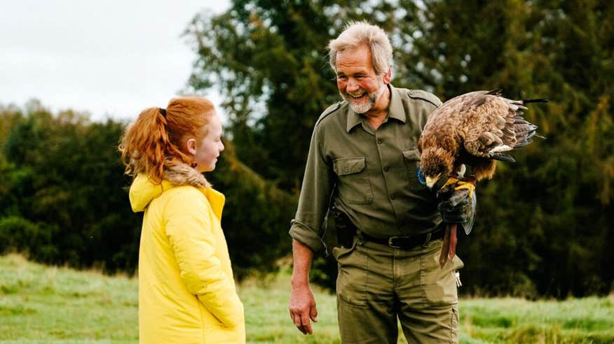 A man showing a girl a bird at Eagles Flying, County Sligo