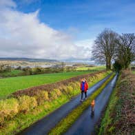 Image of a woman walking her dog along the Beara Way