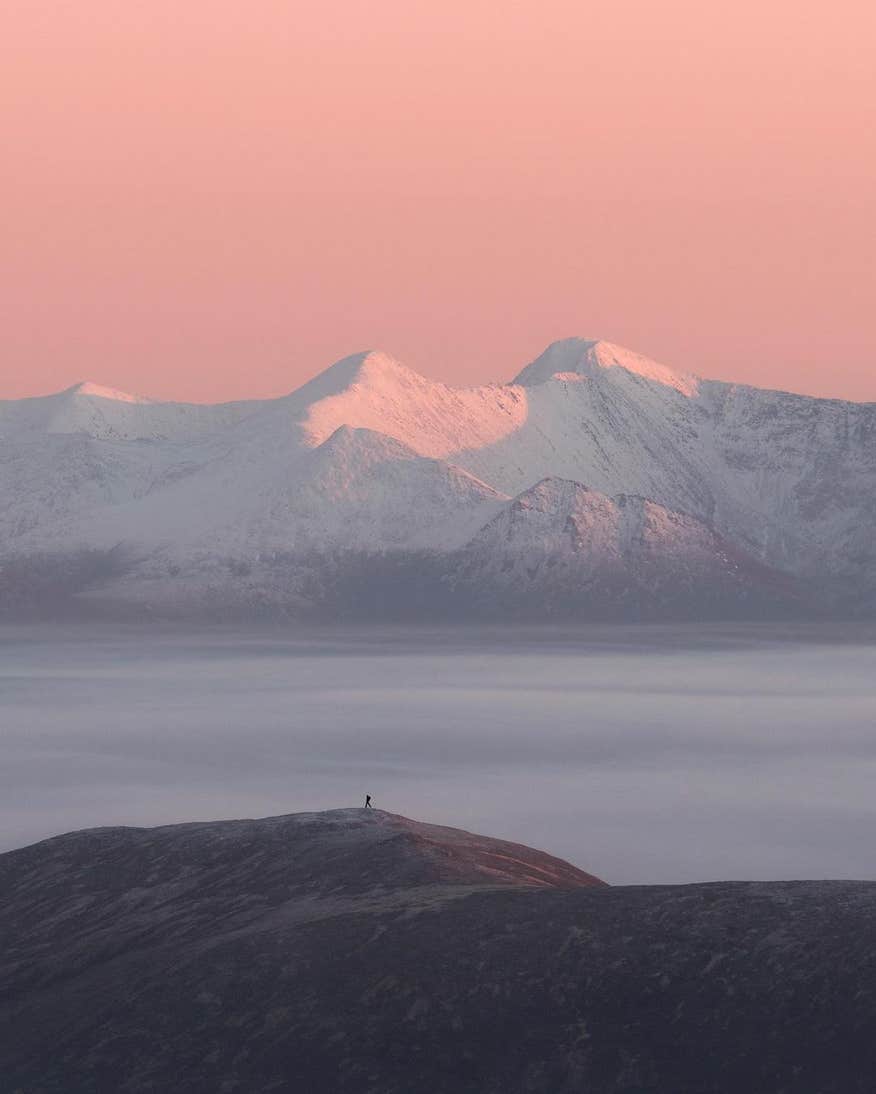 MacGuillicuddy's Reeks mountain range with the sun setting over the top in the winter.