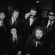 Ole 60, black and white photo of 6 men in dark suits and ties.