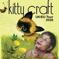 A woman smiling looking up at a cartoon image of a cat