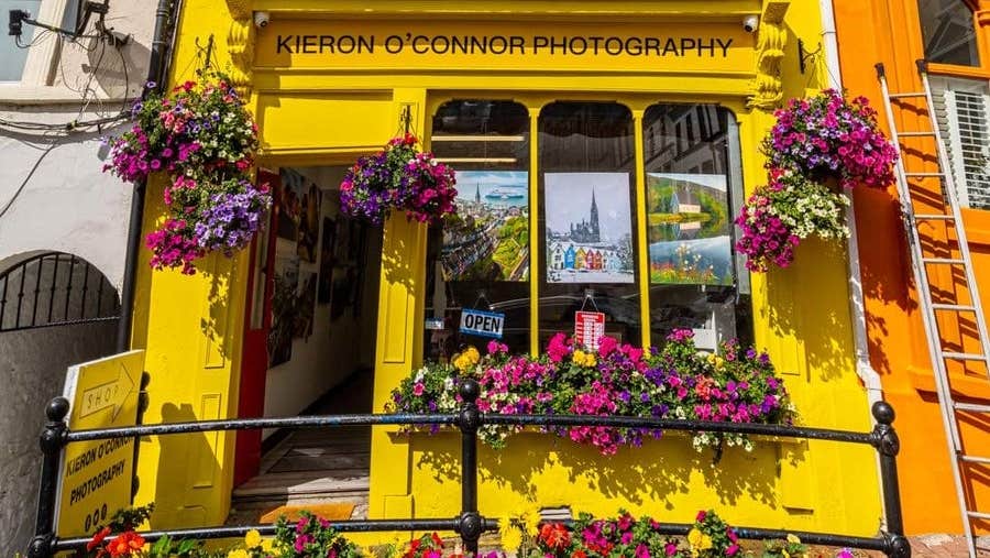 Colourful exterior of a photographic gallery with window boxes and displays of flowers