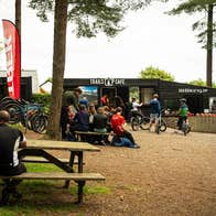 People sitting on picnic benches outside a café