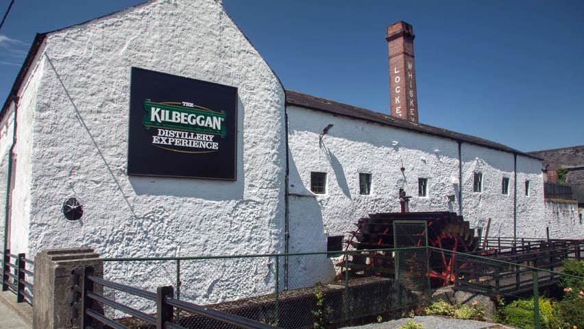 The exterior of the Kilbeggan Distillery Experience building with the old chimney in the background
