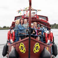Viking Tours Cruise in Athlone, Co.Westmeath - small brown boat on a wide body of water with people standing around the front of boat.
