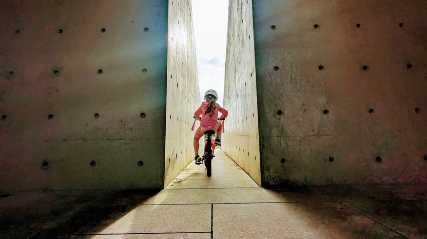 A little girl cycling through the Oulart Hill monument in County Wexford.