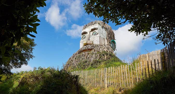 Wooden sculpture of giant man with a beard in a park