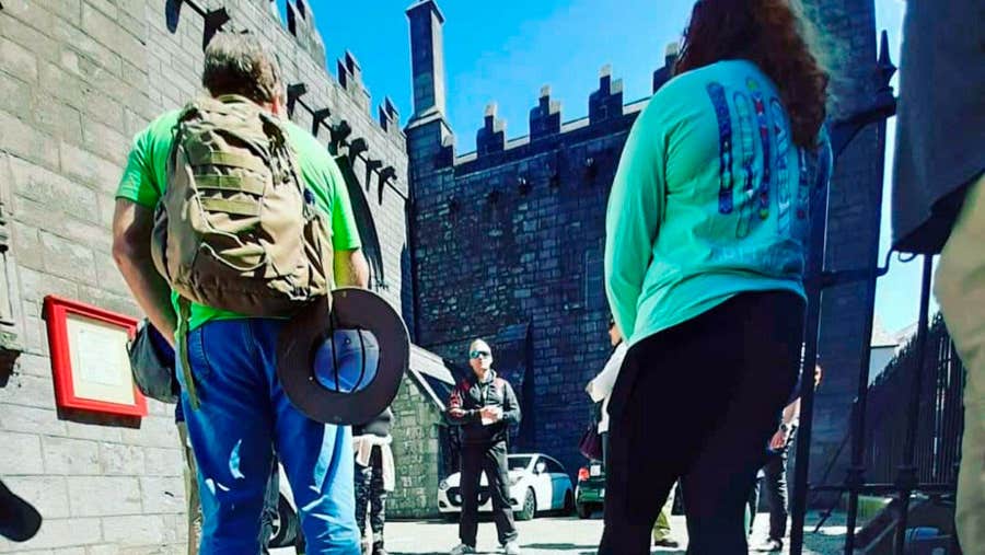 A small group of people on a guided walking tour of Galway City with the guide standing in the background