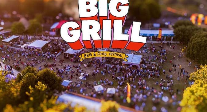 Distant overhead view of festival site with various size tents and marquees and a large crowd.