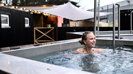 A lady sitting in the cold plunge pool at The Hot Box Sauna Inchicore