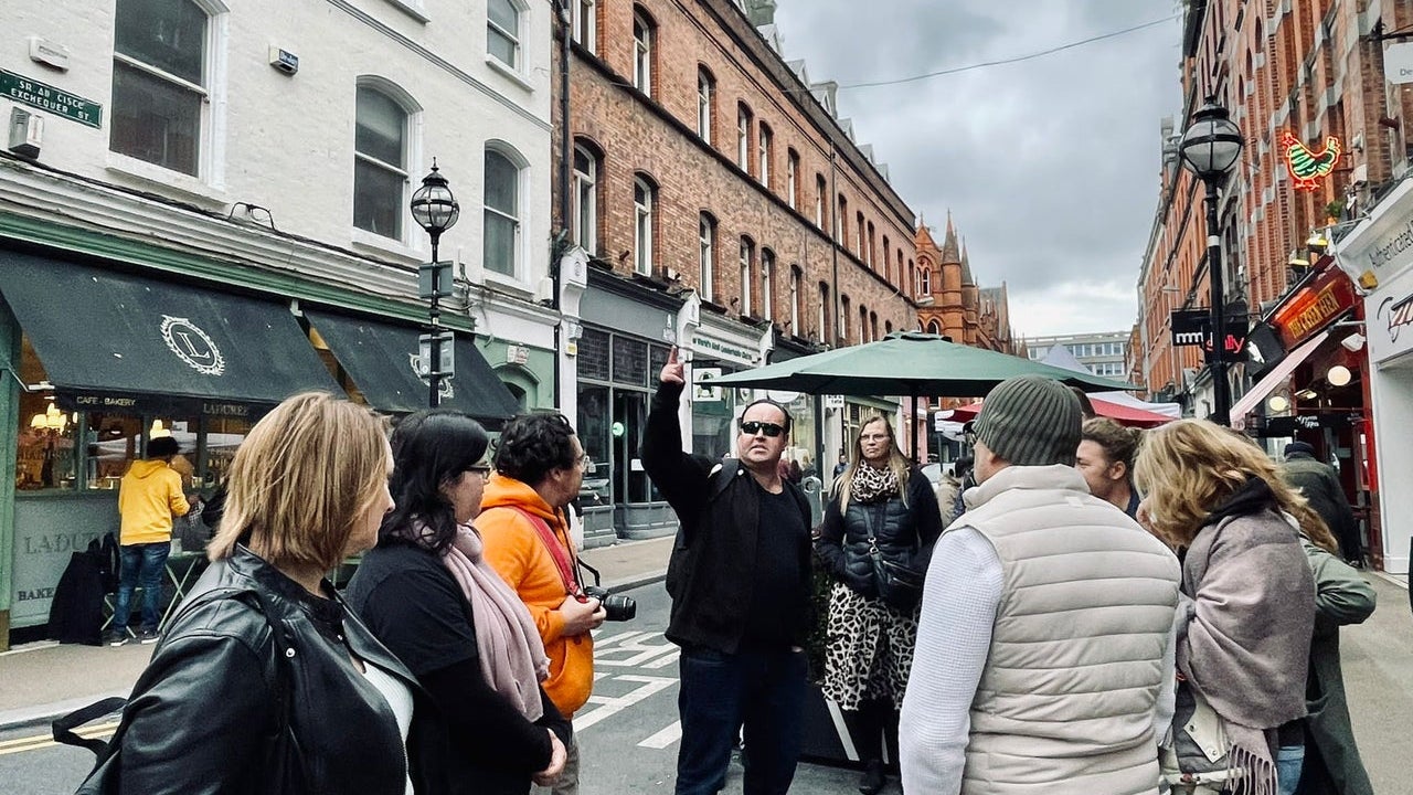 A tour group and guide on a busy city street