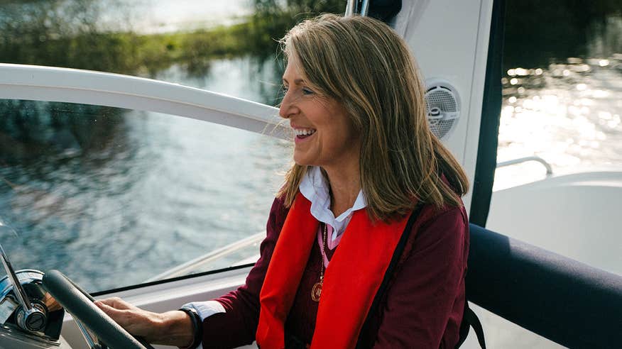 Woman wearing a lifejacket sailing in a boat on the River Shannon