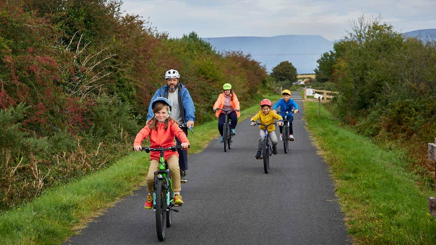 A family cycling the Waterford Greenway