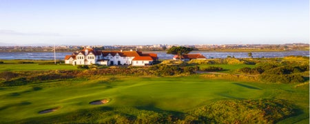 A view of a large clubhouse overlooking a golf course