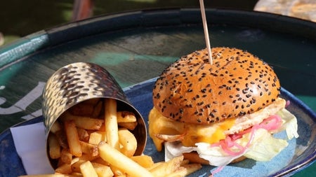 A burger with a sesame seed bun and side chips form the menu at The Bloody Stream