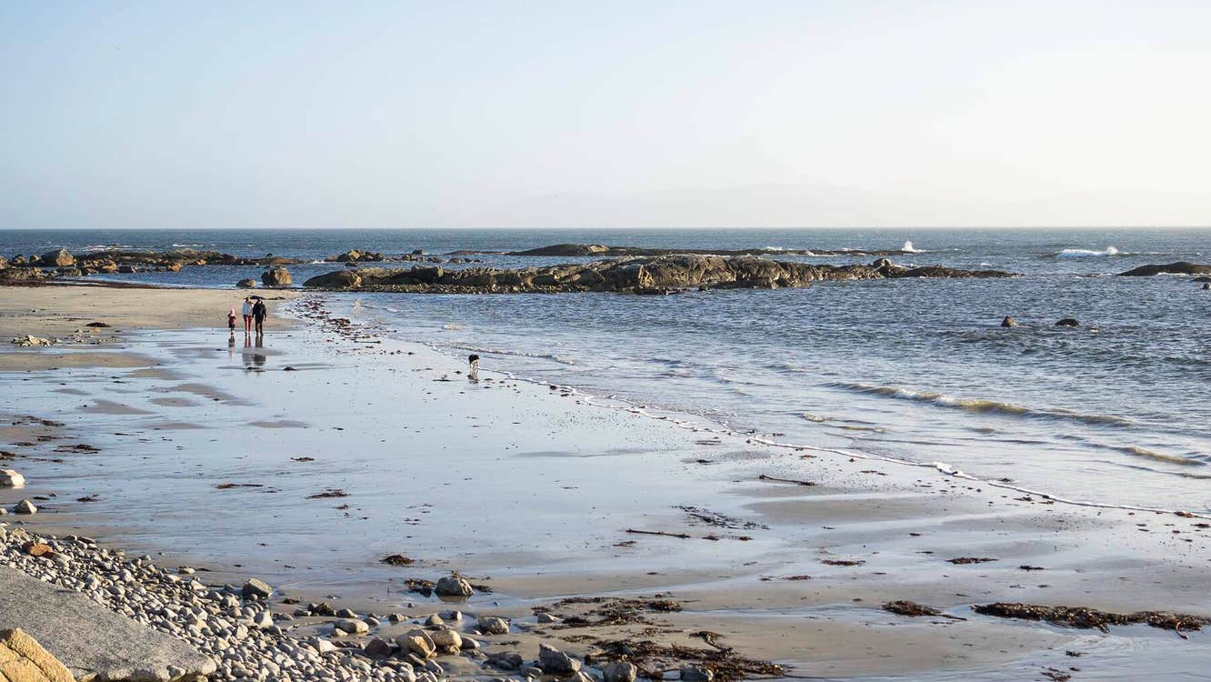 Stone and sand beach with people walking