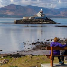 A couple looking out at Fenit Lighthouse, Co Kerry
