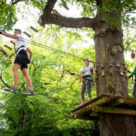People wearing safety gear walking across ropes at Lough Key Forest and Activity Park, Roscommon