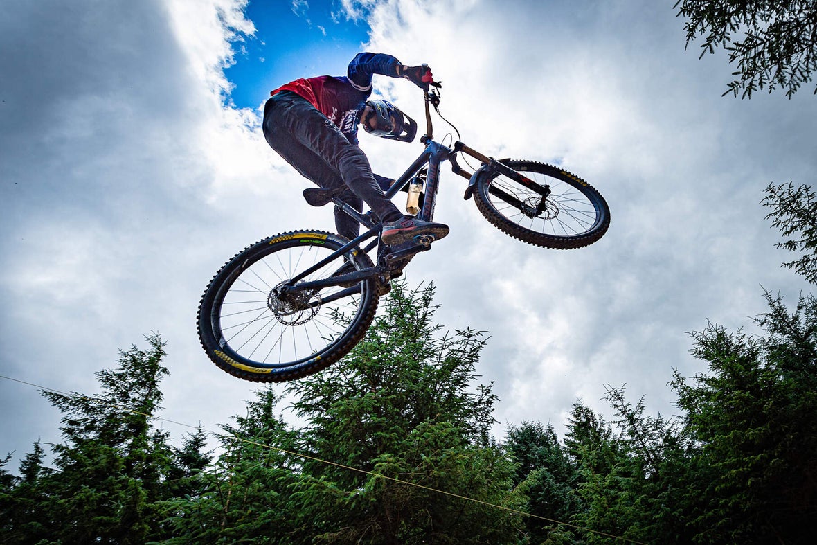 A shot from below of a man on a BMX bike going over a jump.