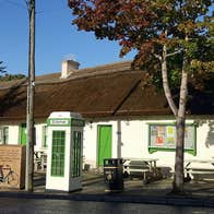 A white washed traditional cottage with a thatched roof