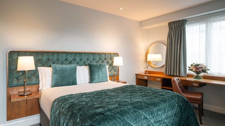 Double bed with green and white sheets