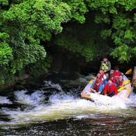 A group of people on a raft going through some rapids