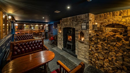 A view of the bar area with a fireplace at The Golden Ball Kilternan