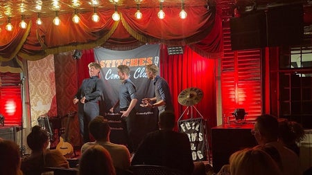 Three comedians performing on a stage