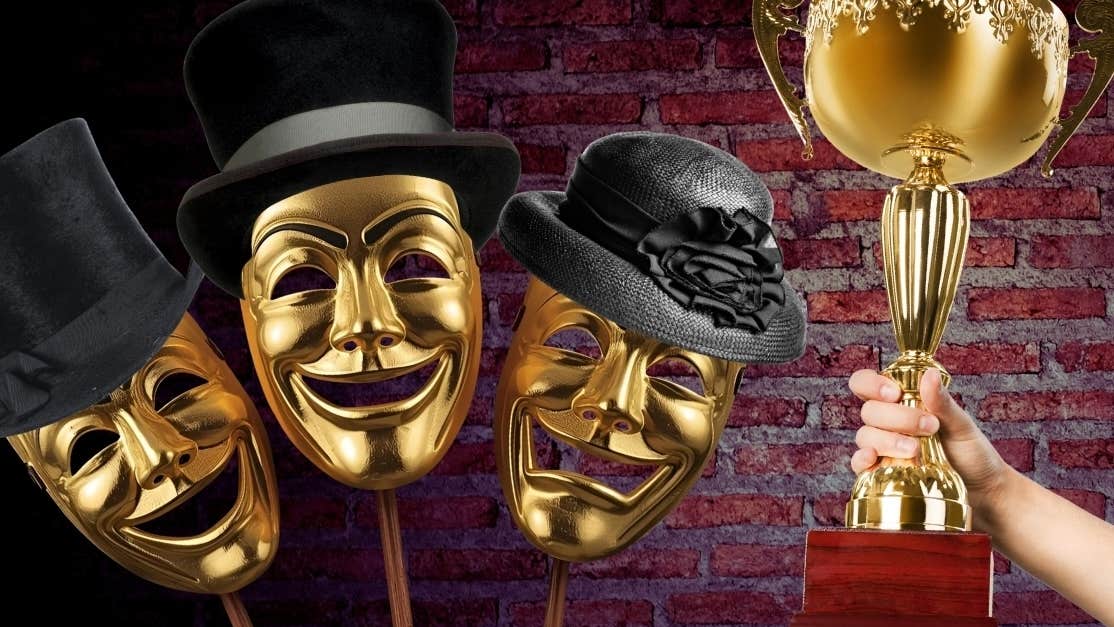 3 gold face masks laughing or crying wearing black formal hats beside hand holding up a large gold trophy