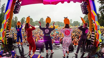 Sing Along Social Gleneagle rear view of people performing on a small outdoor stage with large audience in the background.
