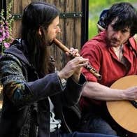 Rennie and Lúan, 2 seated men playing musical instruments.