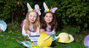 Easter Trail Strokestown Park, 2 young girls laid on grass with easter bunny ears, baskets and eggs