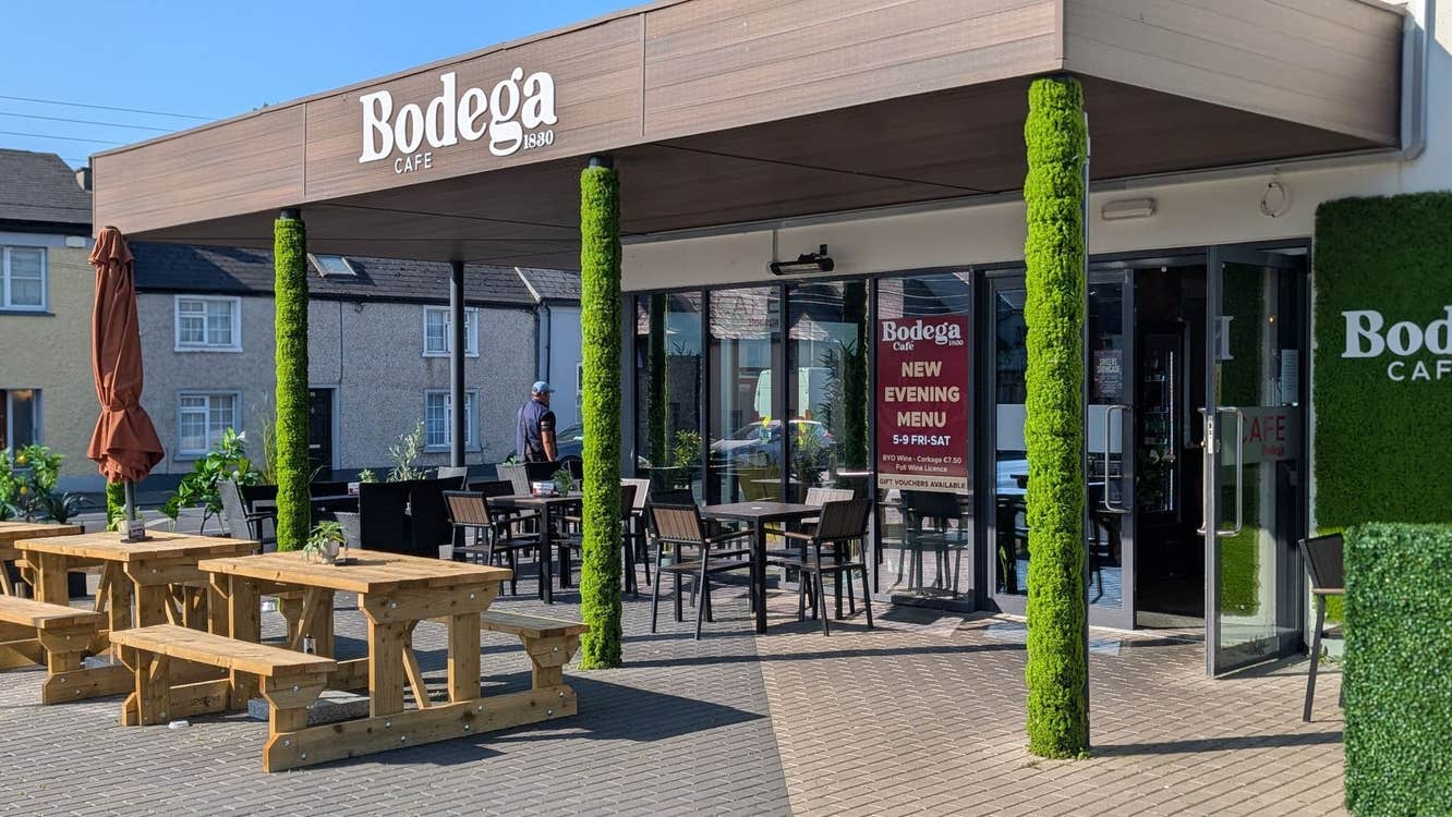 Exterior of a café with a dining area outside the door and on the paved street
