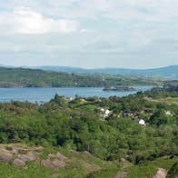 A view of Bantry Harbour in the distance surrounded by forestry taken from a vantage point within the Nature Reserve known as Lady Bantrys Lookout
